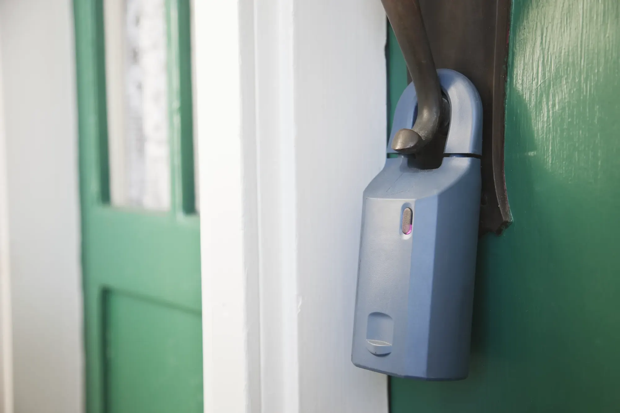 Key lockbox hanging on the door handle of a property