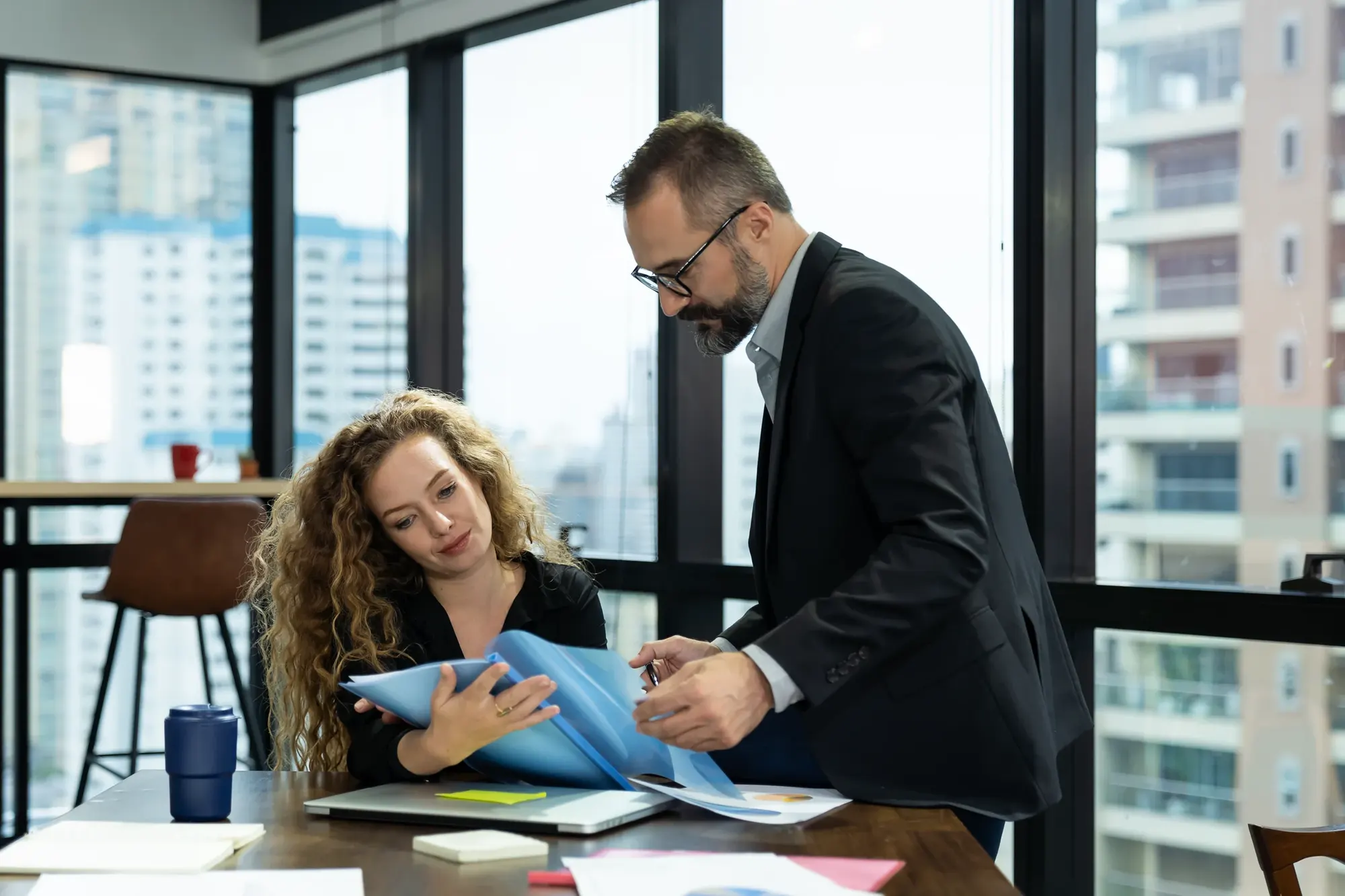 Two advisors reviewing loan documents together at a desk